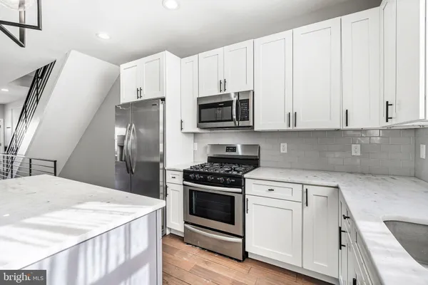 a kitchen with granite countertop white cabinets and white appliances