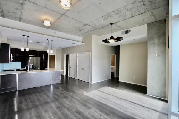 a view of a kitchen with refrigerator and wooden floor