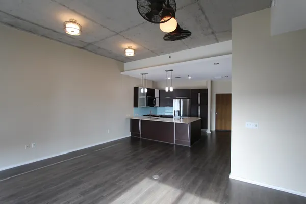 a view of living room with stainless steel appliances wooden floor and view living room