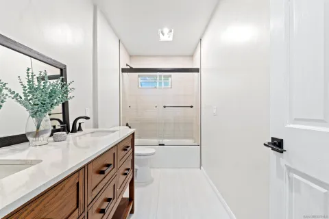 a bathroom with a granite countertop sink a mirror and a bathtub