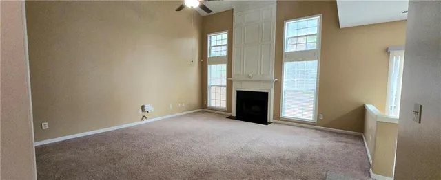 an empty room with windows and fireplace
