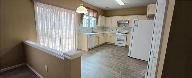 a kitchen with white cabinets and white appliances