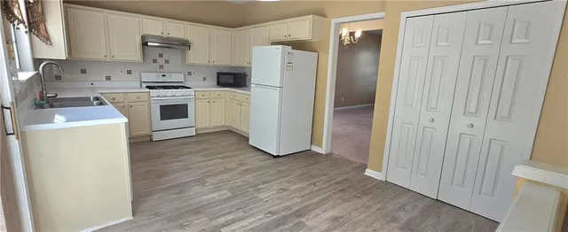 a kitchen with white cabinets and white appliances
