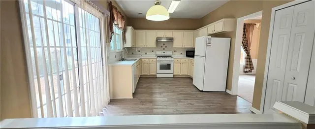a kitchen with refrigerator cabinets and wooden floor