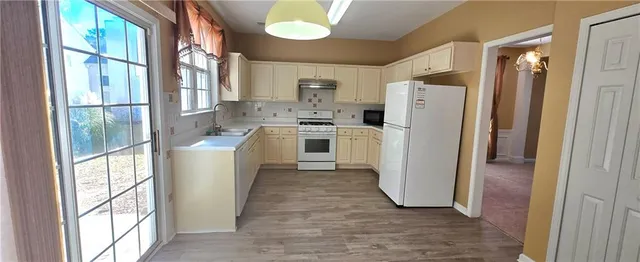 a kitchen with a refrigerator a stove and a window