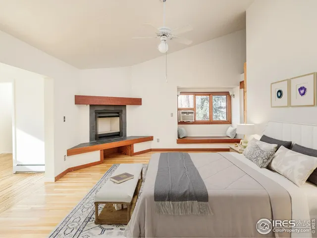 a bedroom with a bed and a dresser with wooden floor