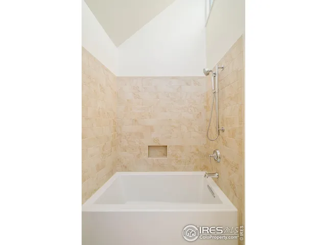 a bathroom with a tub shower sink and vanity