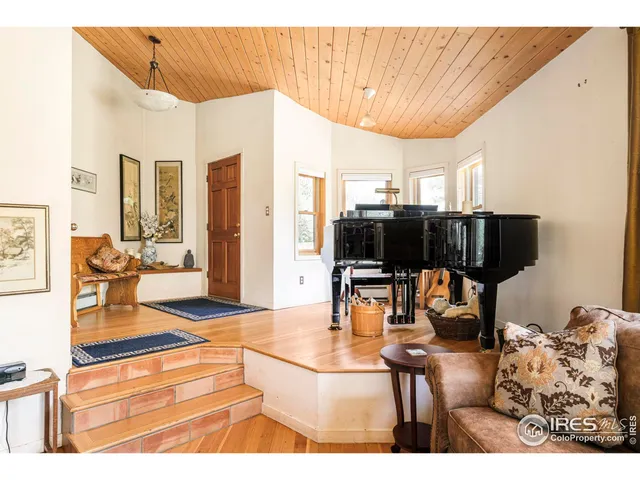 a living room with furniture a flat screen tv and kitchen view