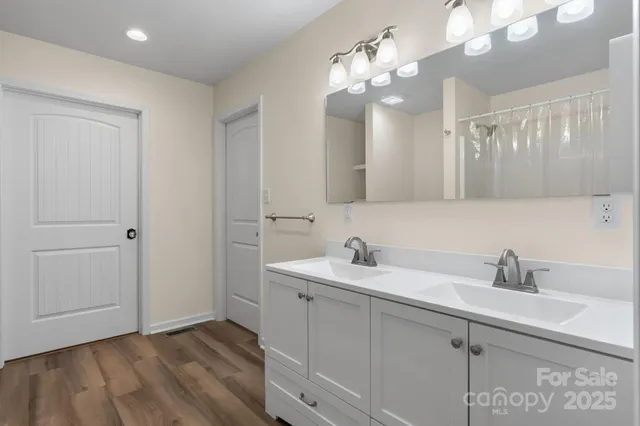 a bathroom with a sink a large mirror and vanity