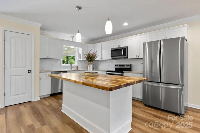 a kitchen with stainless steel appliances granite countertop a refrigerator sink and microwave