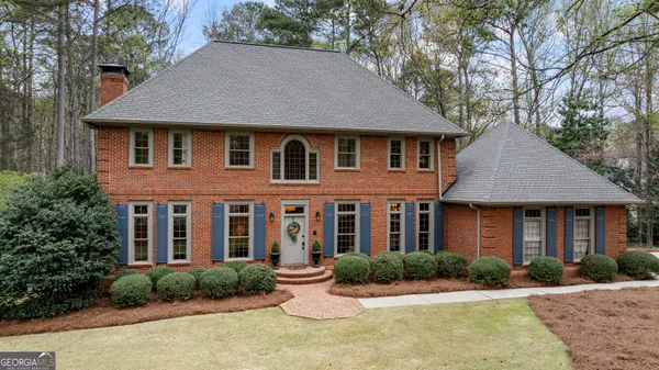a front view of a house with yard and green space