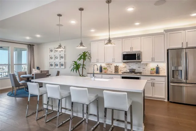 a living room with furniture a flat screen tv and kitchen view