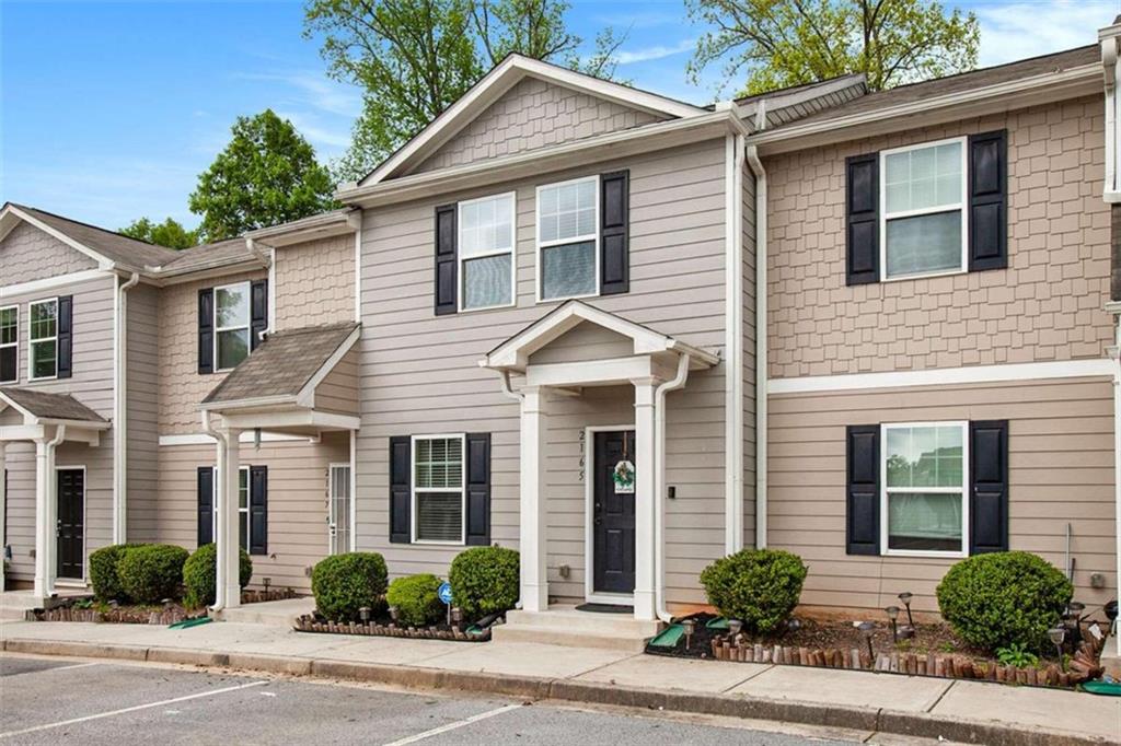 2165 Chadwick Road Southwest Atlanta, GA 30331 - Photo 1 of 1 a view of a white house with a large windows potted plants and a table and chairs