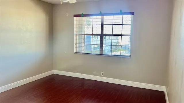 an empty room with wooden floor and a window