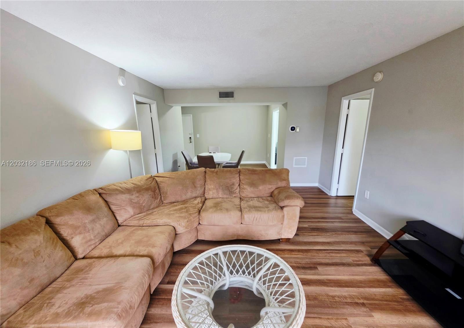 4164 Inverrary Drive, Unit 204 Lauderhill, FL 33319 - Photo 12 of 28 a living room with a couch and a chandelier