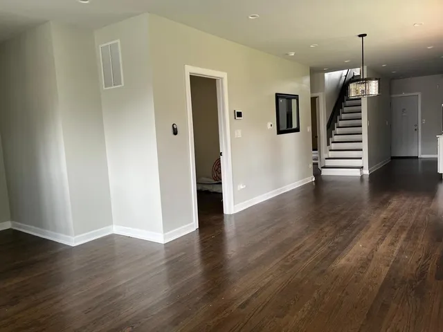 a view of a hallway with wooden floor and stairs