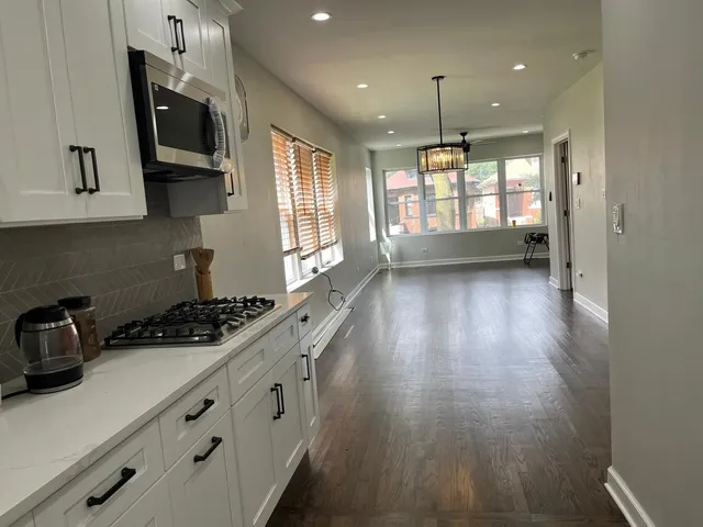 a kitchen with sink a microwave a stove and cabinets