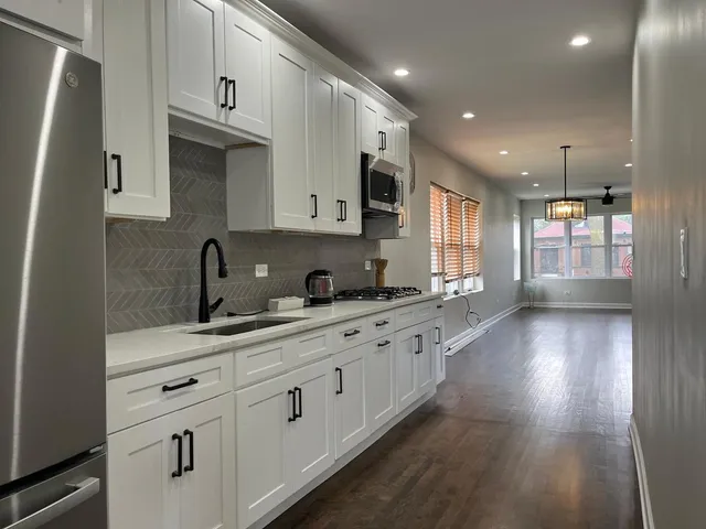 a kitchen with granite countertop a sink a window and stainless steel appliances