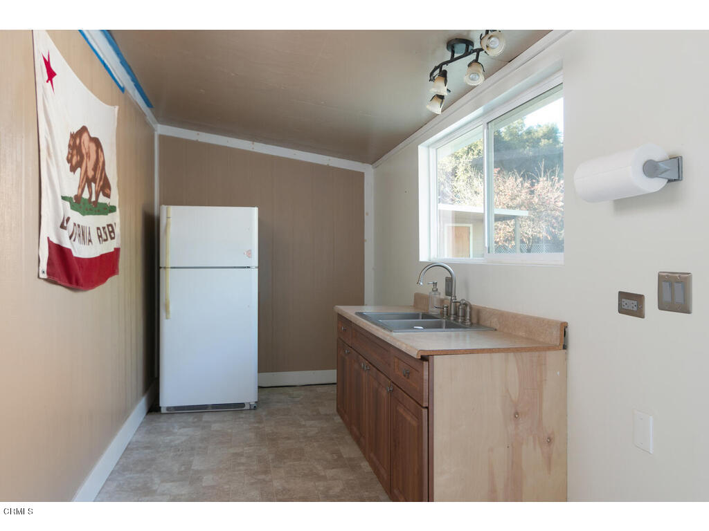 564 Burnham Road Oak View, CA 93022 - Photo 19 of 37 a hall with a stove a refrigerator and a window