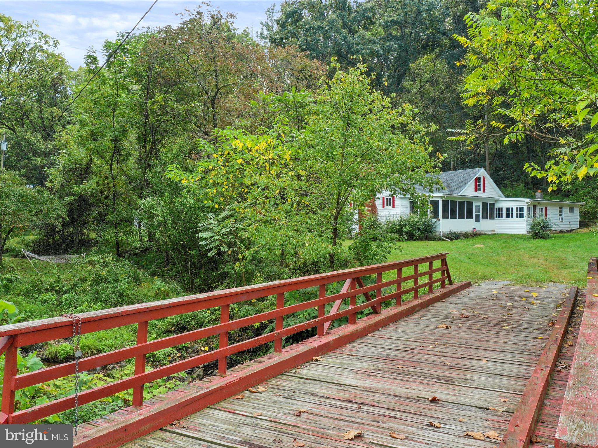 a balcony with wooden floor and trees in the background