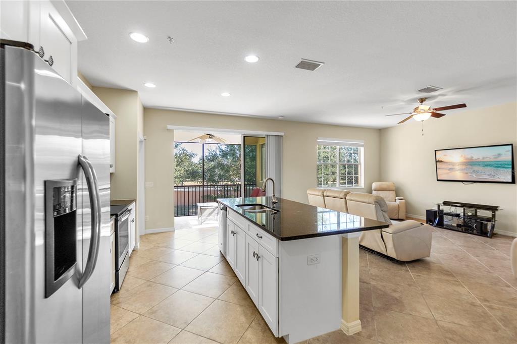 8141 Miramar Way, Unit 8141 Lakewood Ranch, FL 34202 - Photo 11 of 26 a large living room with stainless steel appliances furniture a rug and a large window