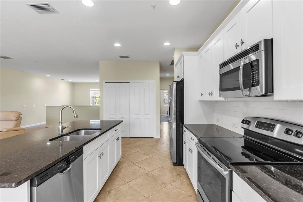 8141 Miramar Way, Unit 8141 Lakewood Ranch, FL 34202 - Photo 12 of 26 a kitchen with stainless steel appliances a sink stove and refrigerator