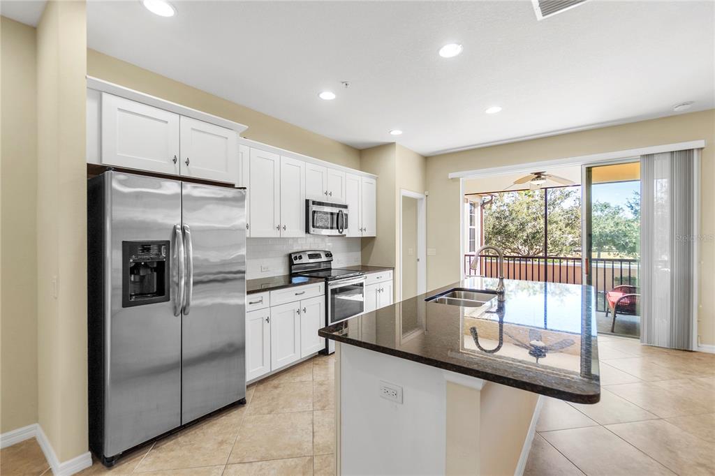 8141 Miramar Way, Unit 8141 Lakewood Ranch, FL 34202 - Photo 10 of 26 a kitchen with stainless steel appliances granite countertop a sink and a refrigerator