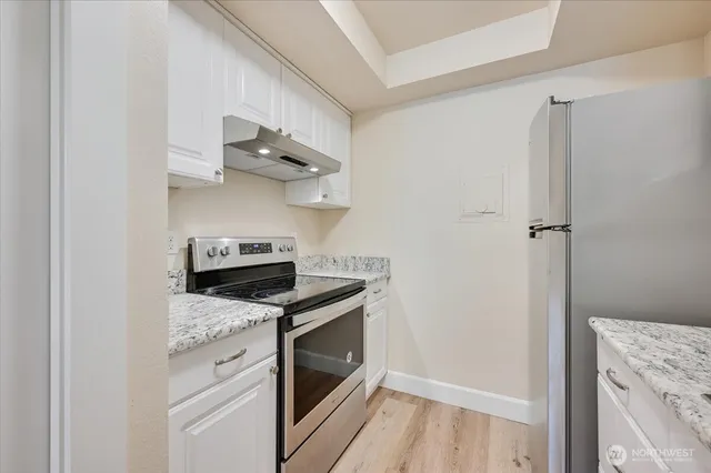 a kitchen with stainless steel appliances granite countertop a stove and a refrigerator