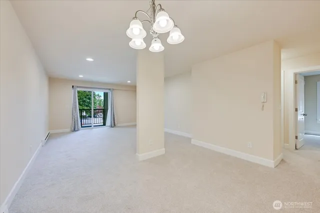 a view of an empty room with a chandelier fan