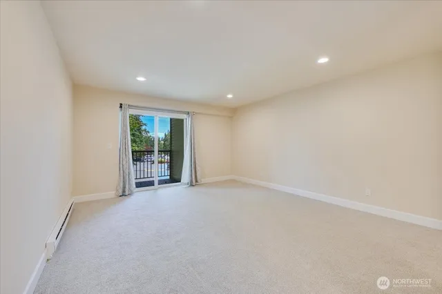 an empty room with floor to ceiling window and an outdoor view