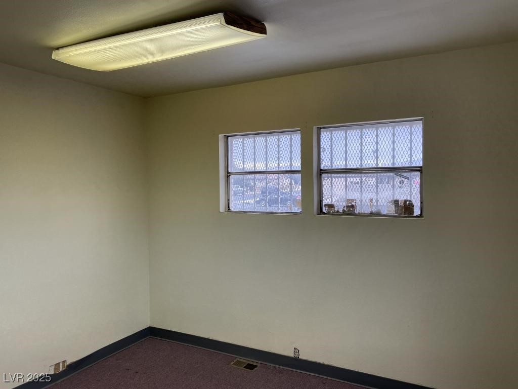3530 North Pecos Road Las Vegas, NV 89115 - Photo 28 of 46 Empty room with visible vents, dark carpet, and baseboards