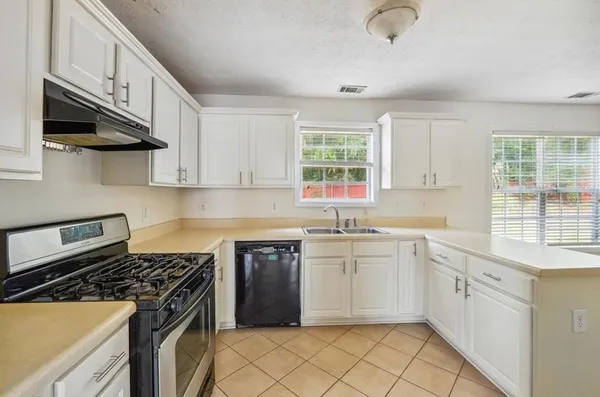 a kitchen with a sink stove and cabinets