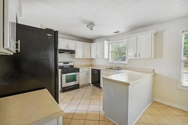 a kitchen with a stove a sink and a refrigerator