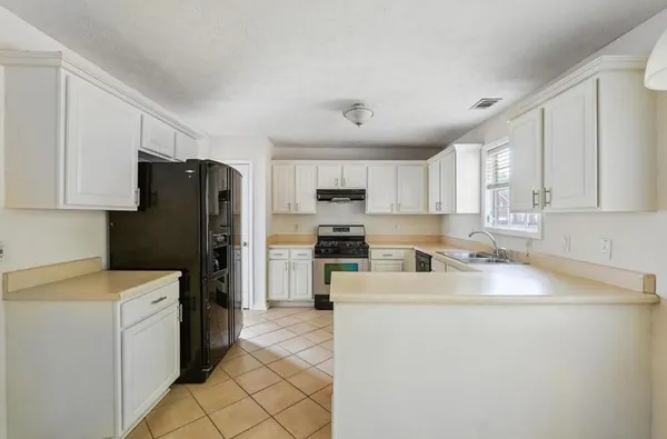 a kitchen with a refrigerator sink and cabinets