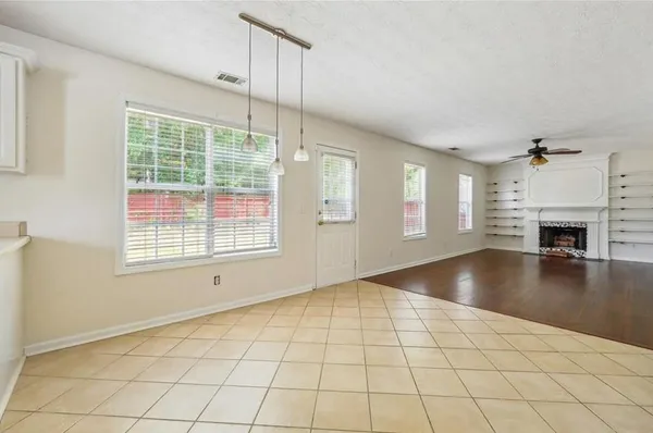 a view of an empty room with a window and fire place