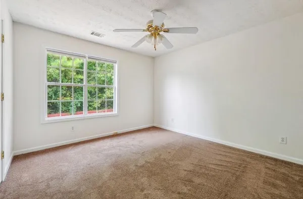 an empty room with a window and a ceiling fan