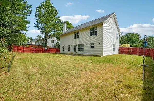 a view of a house with backyard and sitting area