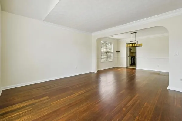 a view of a livingroom with wooden floor and a window