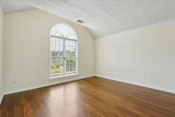 an empty room with wooden floor and a window