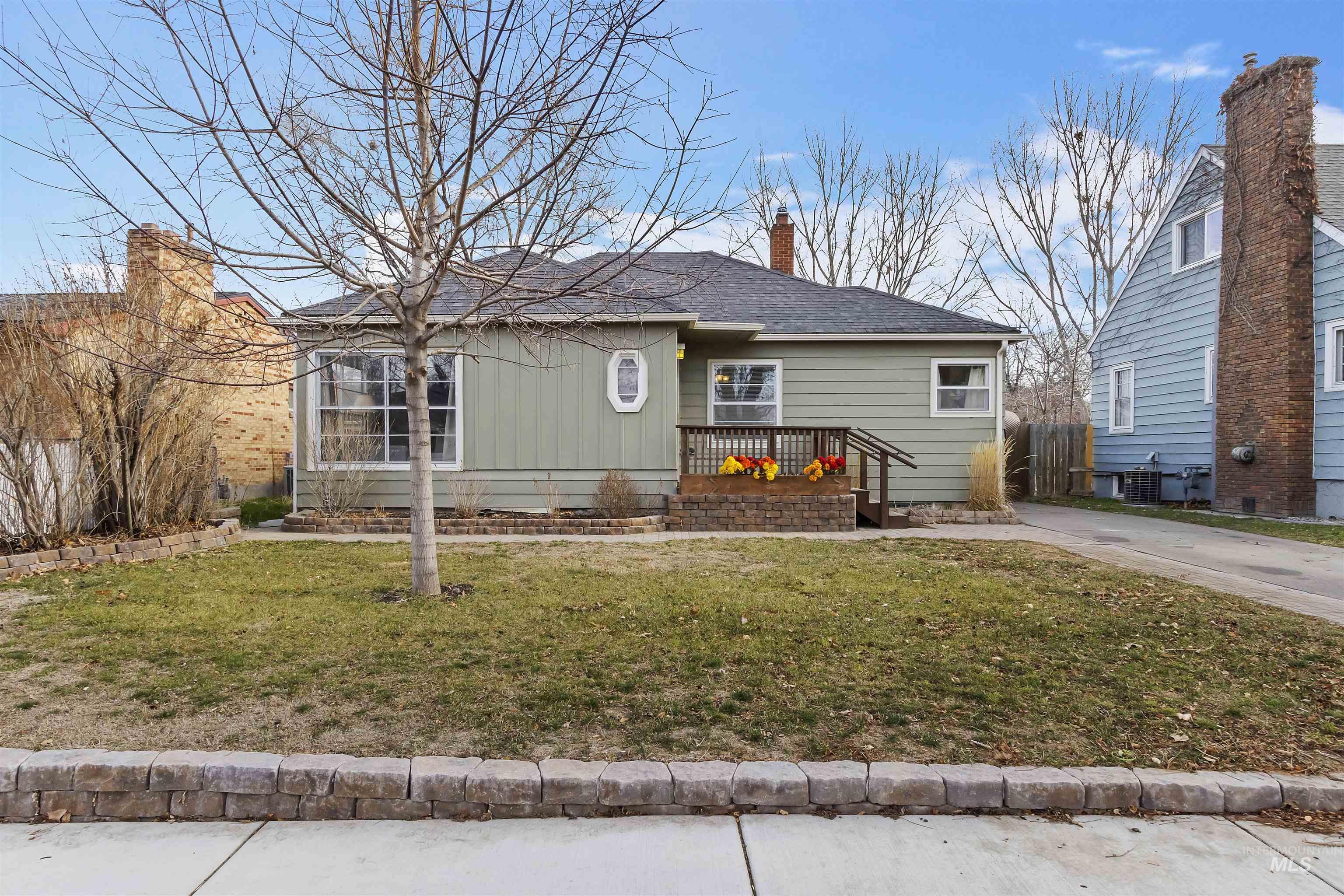 View of front of property with a chimney, a front lawn, board and batten siding, and a shingled roof