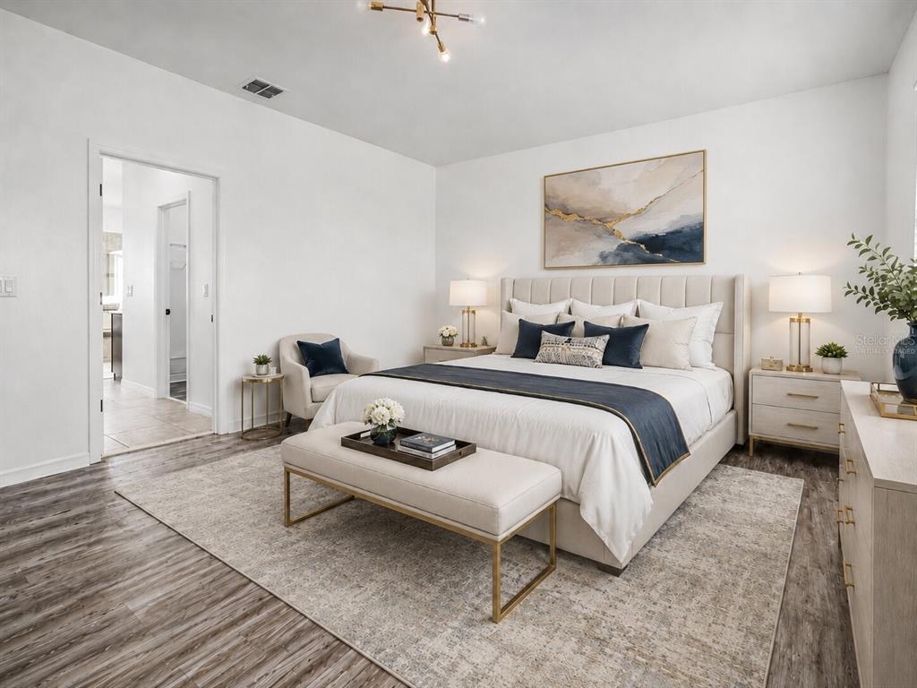 8531 Geddes Loop Orlando, FL 32836 - Photo 10 of 20 a bedroom with a bed a couch and wooden floor