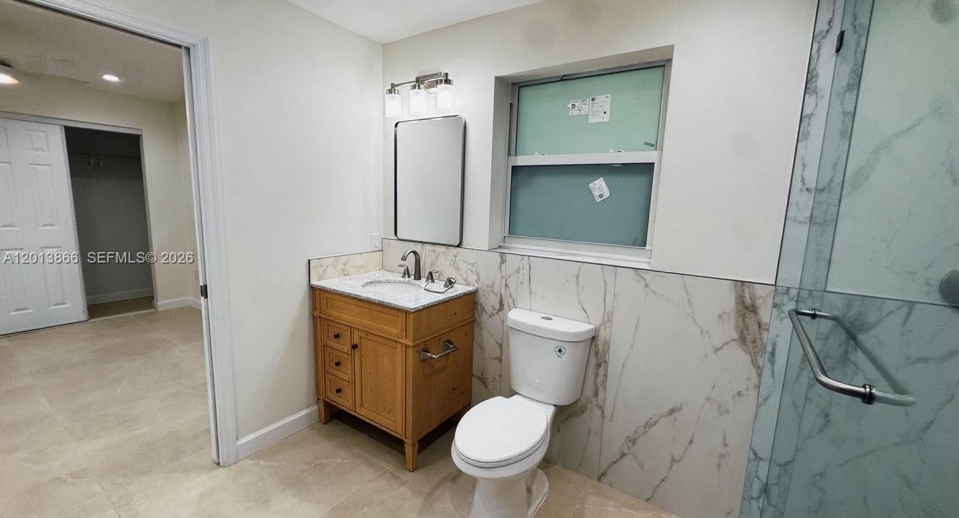 8440 Southwest 107th Street, Unit GH Miami, FL 33156 - Photo 11 of 22 a bathroom with a toilet a sink and mirror