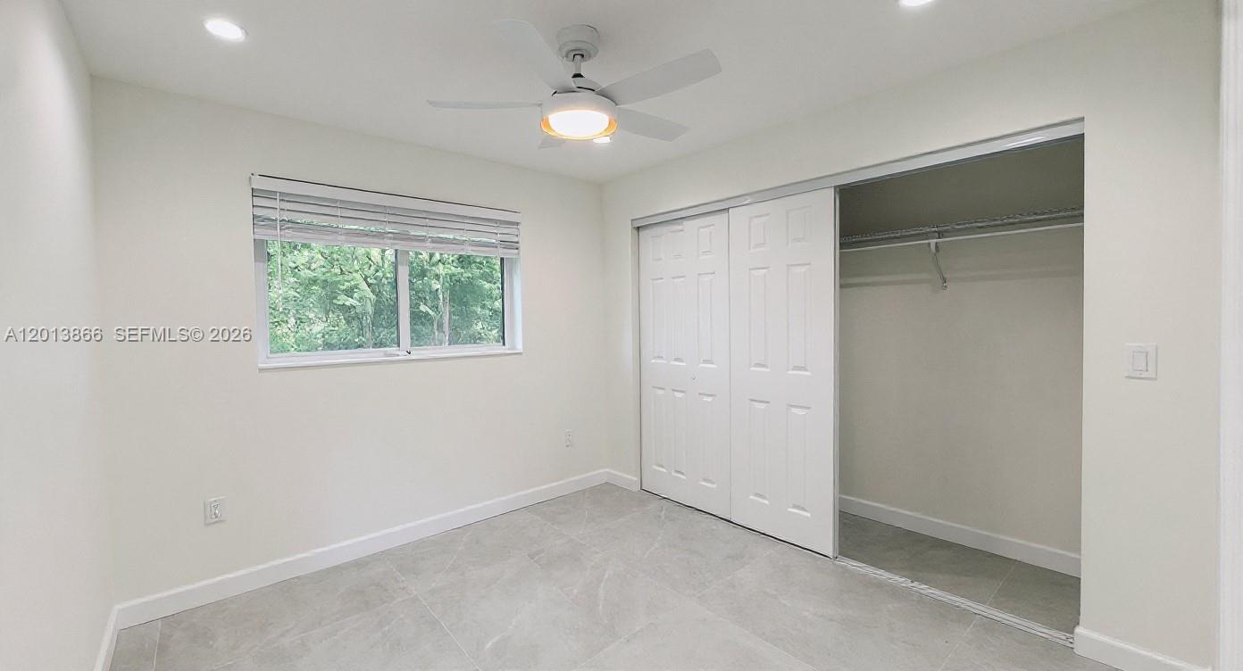 8440 Southwest 107th Street, Unit GH Miami, FL 33156 - Photo 13 of 22 an empty room with windows and fan