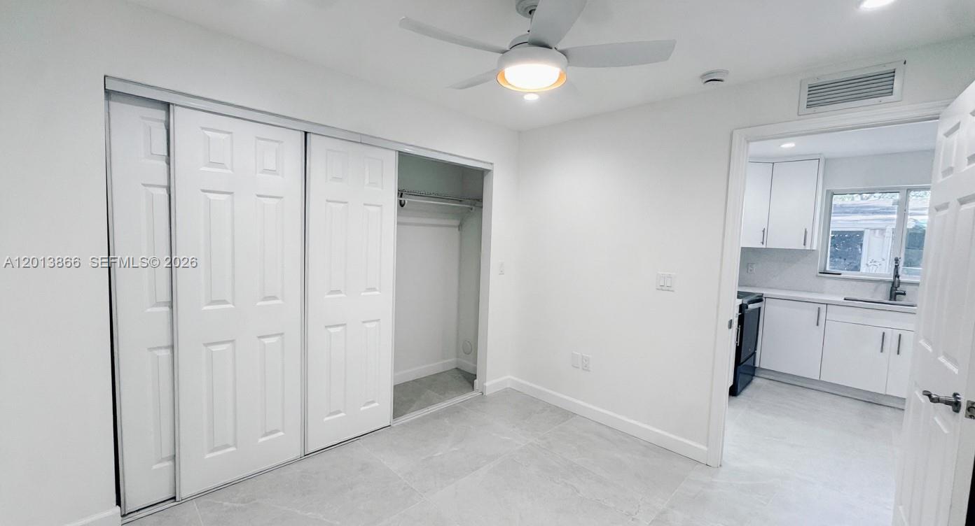 8440 Southwest 107th Street, Unit GH Miami, FL 33156 - Photo 14 of 22 a view of a kitchen with a sink and dishwasher a refrigerator with white cabinets