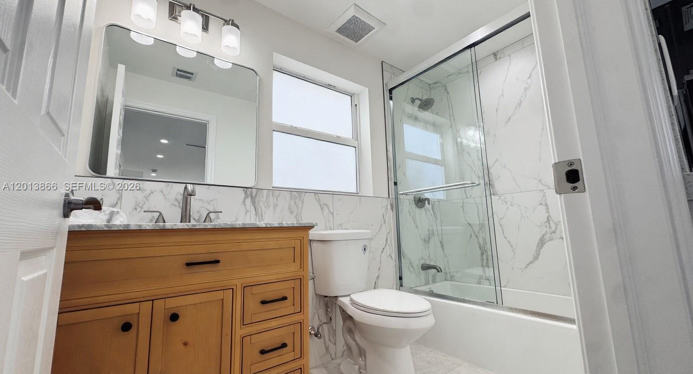 8440 Southwest 107th Street, Unit GH Miami, FL 33156 - Photo 18 of 22 a bathroom with a granite countertop sink toilet and shower