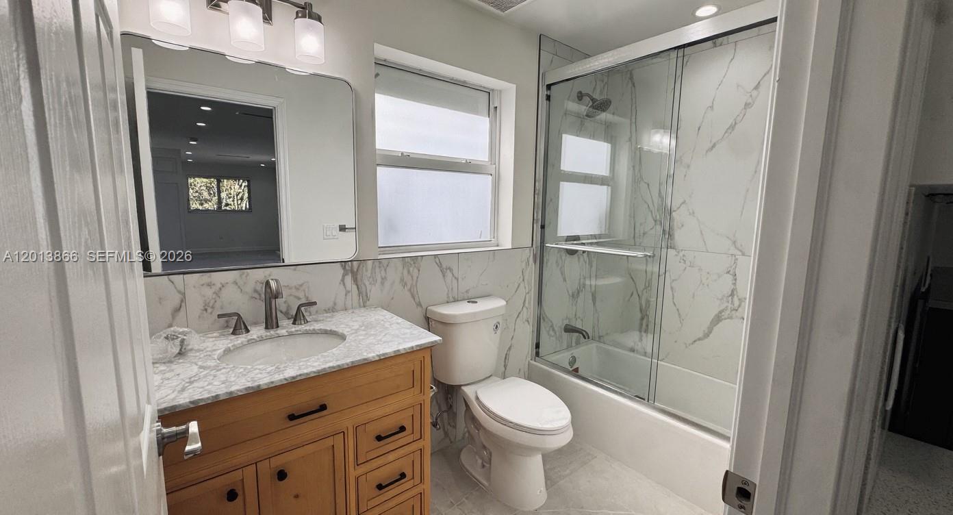 8440 Southwest 107th Street, Unit GH Miami, FL 33156 - Photo 19 of 22 a bathroom with a granite countertop sink toilet and shower