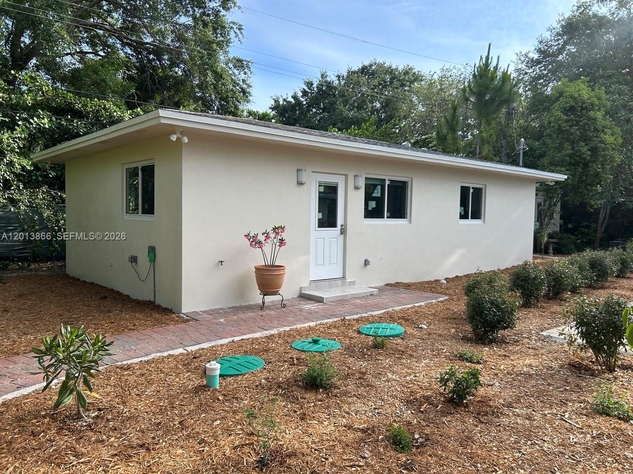 8440 Southwest 107th Street, Unit GH Miami, FL 33156 - Photo 22 of 22 a backyard of a house with potted plants and large tree