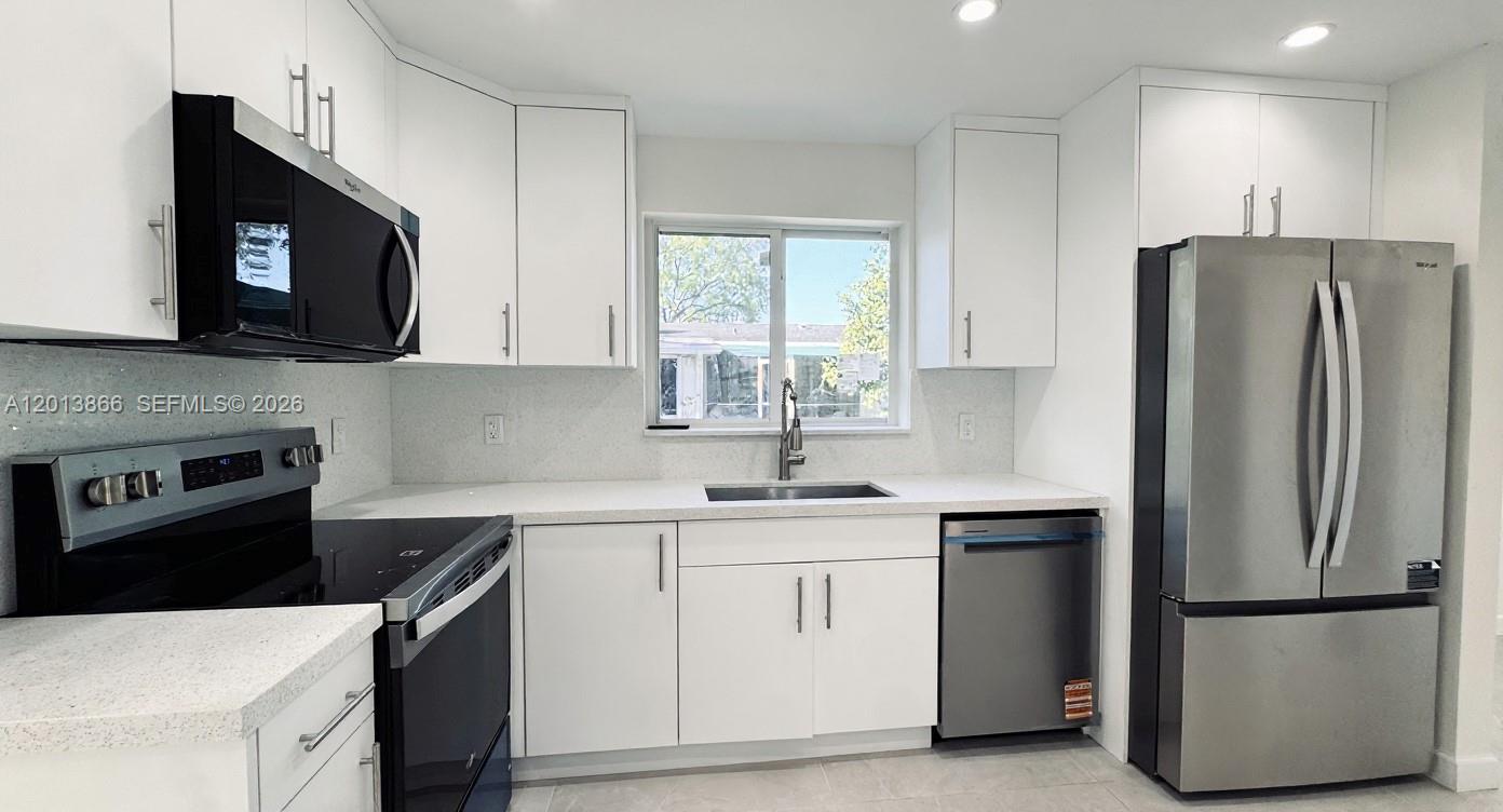 8440 Southwest 107th Street, Unit GH Miami, FL 33156 - Photo 4 of 22 a kitchen with a sink stove and refrigerator
