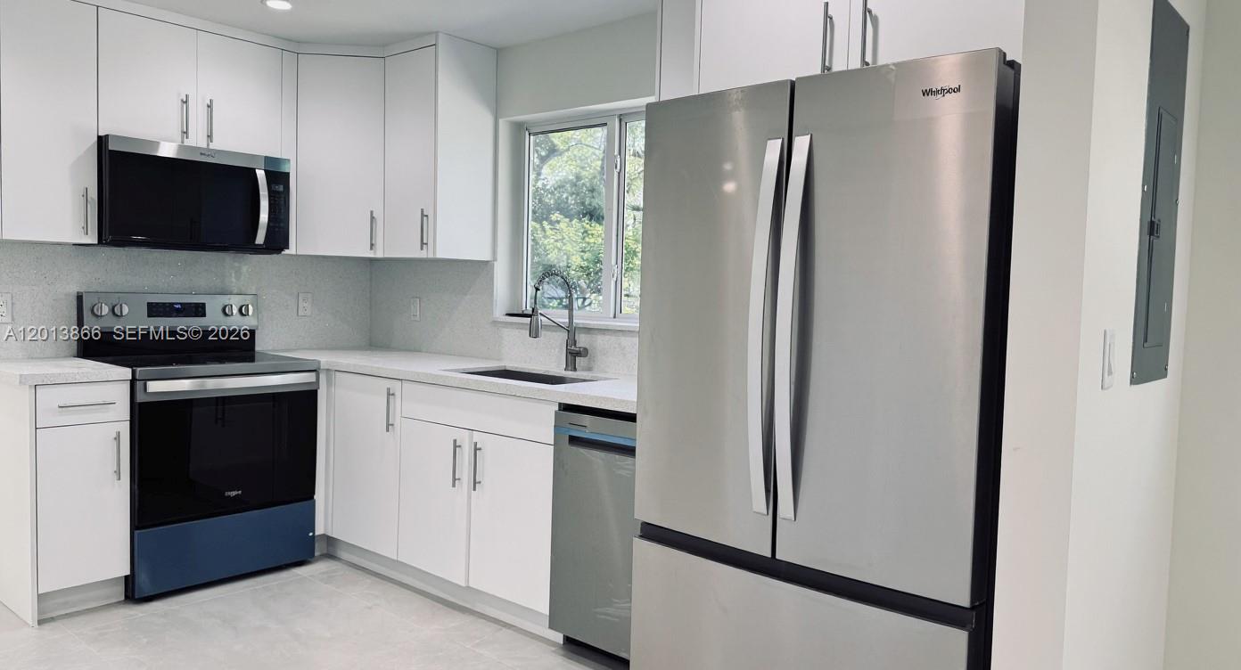 8440 Southwest 107th Street, Unit GH Miami, FL 33156 - Photo 5 of 22 a kitchen with stainless steel appliances a refrigerator sink and microwave