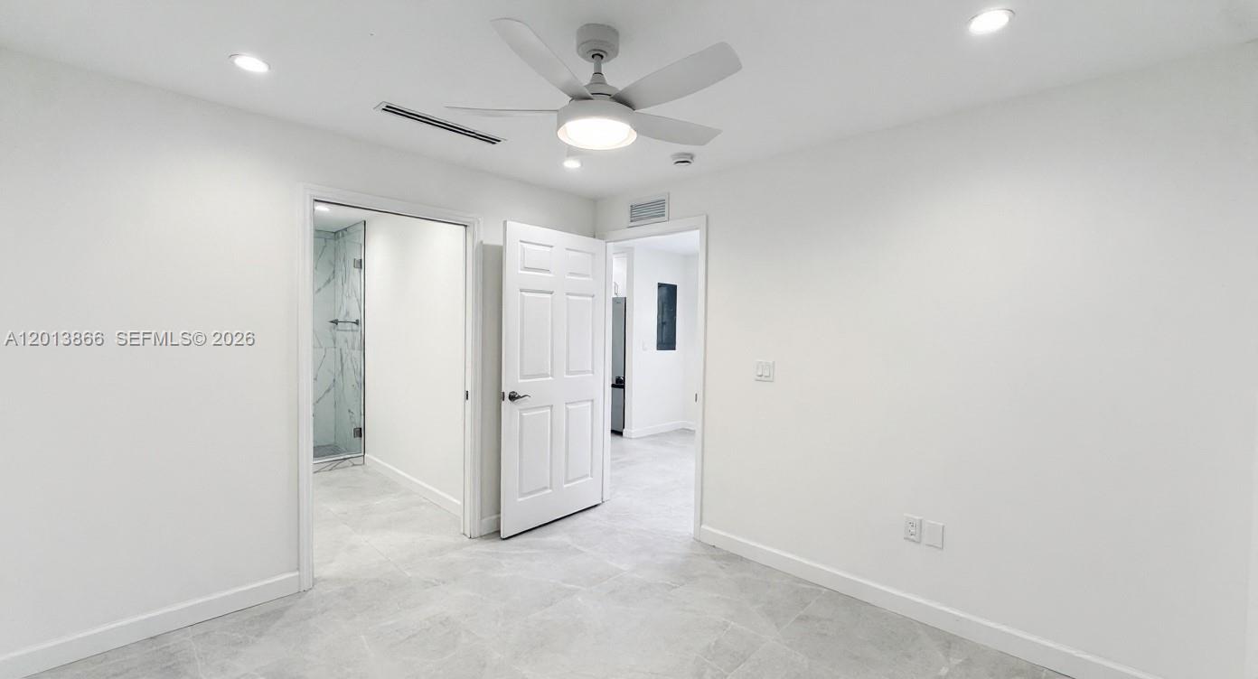 8440 Southwest 107th Street, Unit GH Miami, FL 33156 - Photo 9 of 22 en empty room with a white walls and ceiling fan